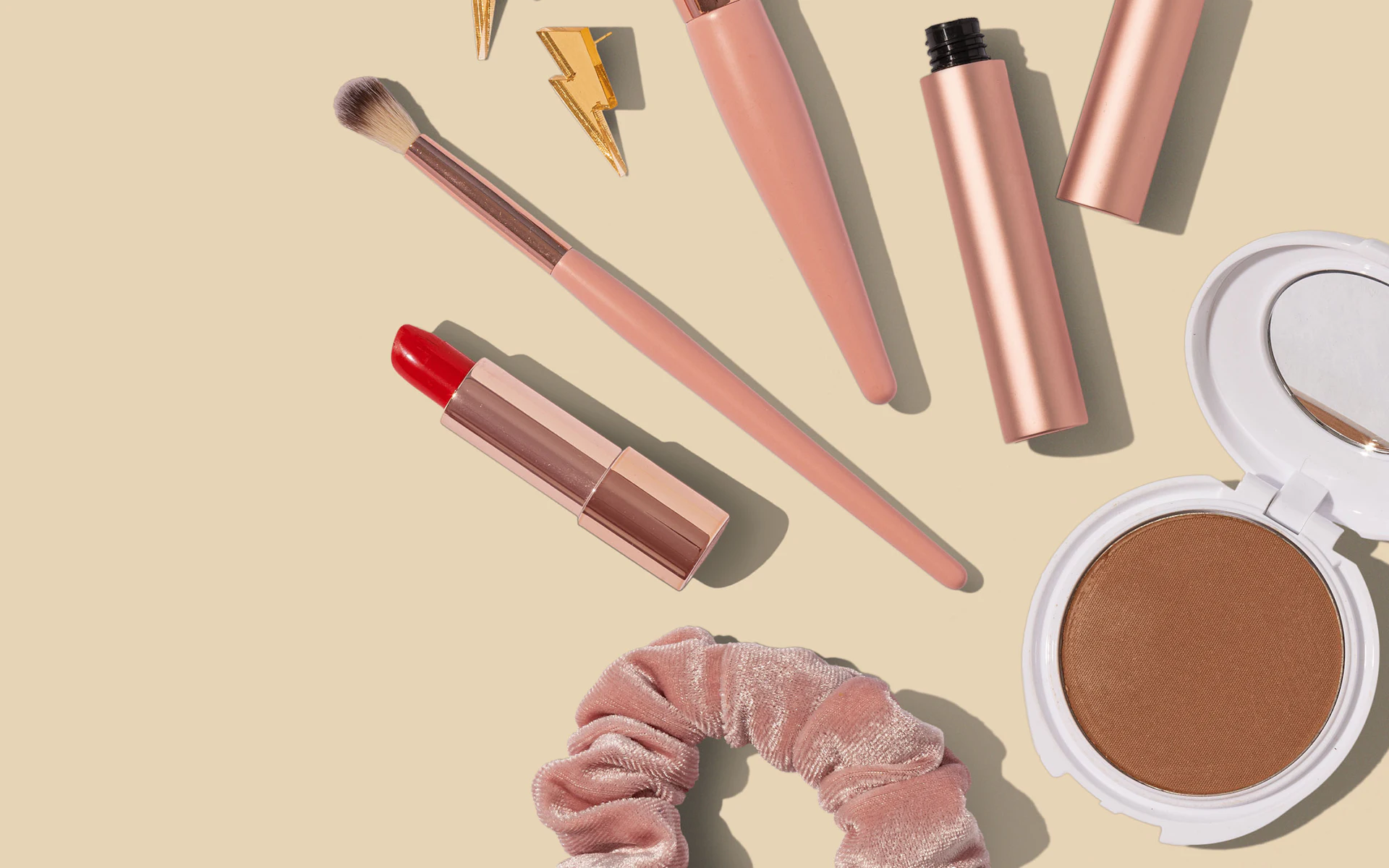 Produtos de maquiagem e skincare sobre fundo bege